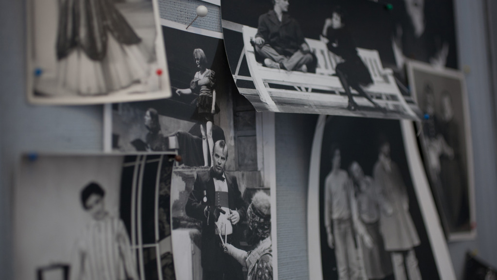 Svartvitt fotografi av gamla föreställningsbilder som hänger på en anslagstavla.