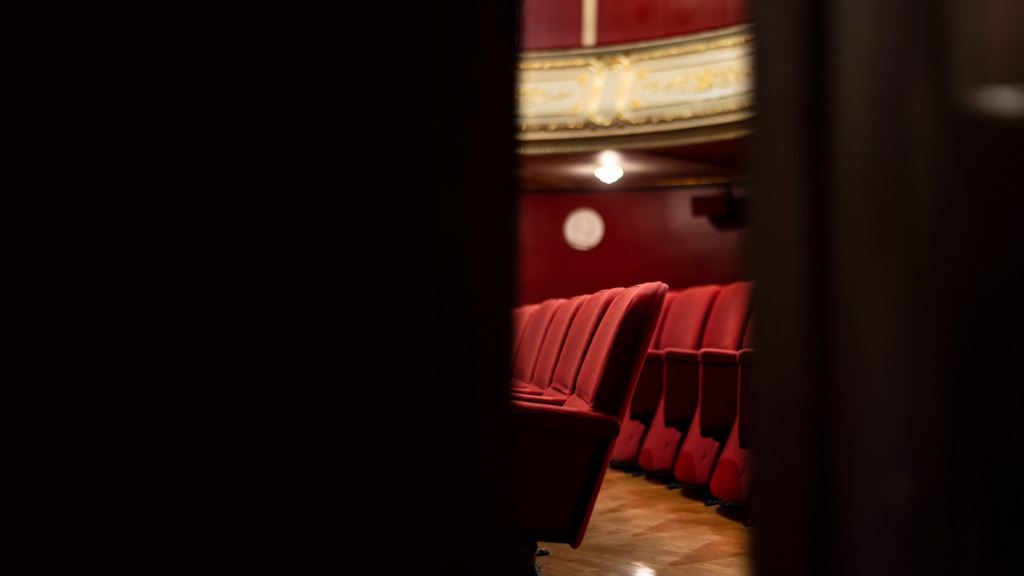 Genom en dörrspringa ses teaterns salong.
