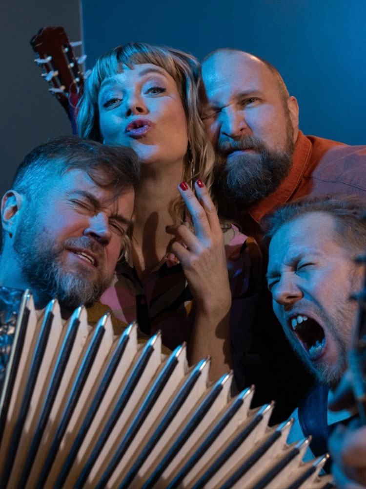 En närbild på de fyra musikerna som sjunger cornelis Vreeswijks sånger, och ett dragspel.